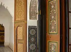 A variety of vernacular decorative Islamic styles in Morocco: wooden panels, zellij tilework, stucco calligraphy, and floral door panels