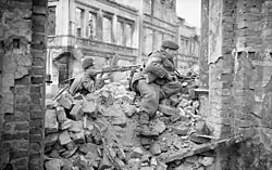 two men in a rubble strewn street