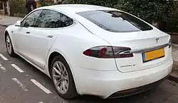 A rear three-quarters view of a white 2016 Tesla Model S