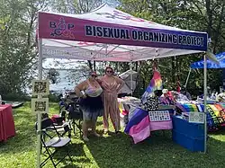 Twp people standing in Bisexual Organizing Project booth standing to pose for the photo