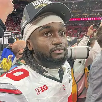 A football player in a baseball hat.