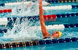 A woman swims the backstroke between two lanes in a swimming pool.