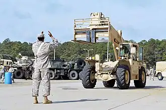 A cargo specialist guides a forklift during safety awareness training on Fort Bragg, N.C.