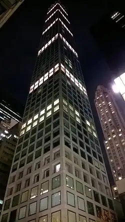 The facade of 432 Park Avenue, illuminated at night. The facade has large square windows.