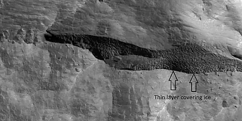 Close view of depression, as seen by HiRISE under HiWish program Arrows indicate where there is a very thin, 1–2&nbsp;m (3.3–6.6&nbsp;ft) covering on what is believed to be ice.