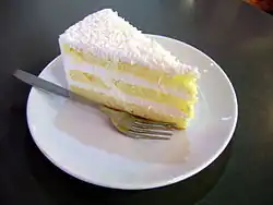 A slice of a layered coconut cake