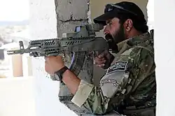Afghan border police aiming an AK type rifle with Picatinny rails, holographic weapon sight and foregrip