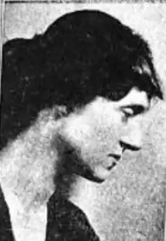 A white woman with dark hair, photographed in profile