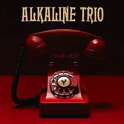 The cover features a red rotory phone with the band's logo in the center and the album title above it. The band's name appears above the phone, colored in beige.