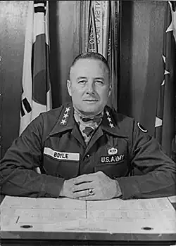 Black and white 1965 upper body photo Lieutenant General Andrew J. Boyle in duty uniform seated at desk