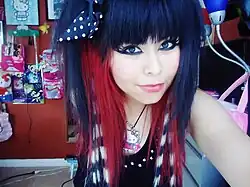 Image 132A teenage American scene girl in 2011, wearing raccoon-striped hair extensions, heavy eyeliner, and colorful accessories typical of the style. (from 2010s in fashion)