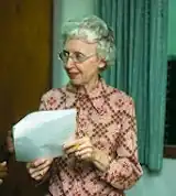 an older white woman holding a document