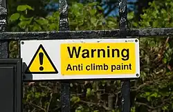 Photograph of a sign on a fence in Greenwich, England, advising of the use of anti-climb paint.