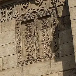 Carved image of doors, on left side of the façade