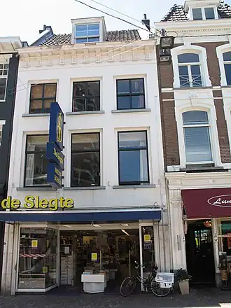 Jansstraat 28, the building where the fire started, in 2010, a white building with a blue awning and sign.