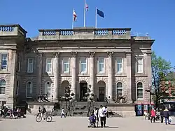 The front of a building built from grey stone with columns in front