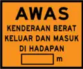 Caution heavy vehicles entering and exiting construction zone ahead, with distance