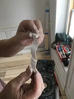 The relief on this short 90-degree return of crown molding was back-cut with a coping saw