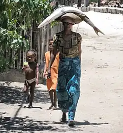 Woman carrying a barracuda in Madagascar