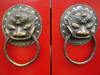 A traditional red Chinese door with Imperial guardian lion knocker