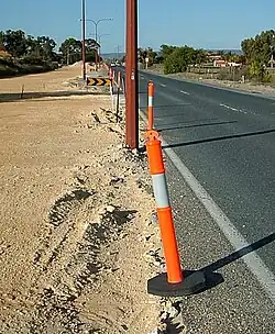 Bollards can be temporary and portable, such as this traffic control bollard separating the road from the worksite