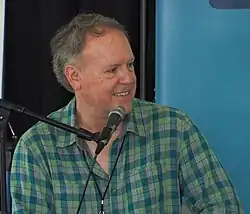 A photo of Lies at the 2024 Gaithersburg Book Festival. Lies is sitting, with a microphone in front of him.
