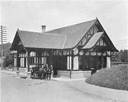 old black-and-white photo of small building with horse and carriage drawn up