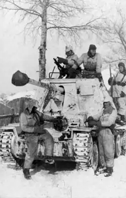 Snow-camouflaged German Marder III jagdpanzer and white-overalled crew and infantry in Russia, 1943