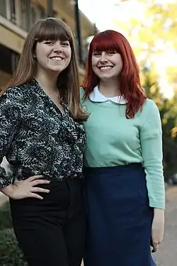 Image 42Two women with blunt bangs wearing vintage-inspired outfits with high-waisted jeans, a peter-pan collar sweater, and retro, 1950s inspired silhouettes in 2013. (from 2010s in fashion)