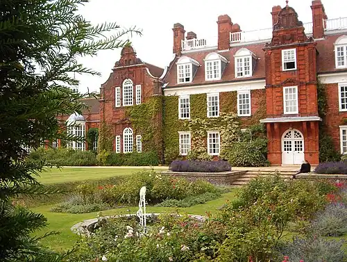 Large, red-brick three-story building; there is a sunken ornamental garden in front.