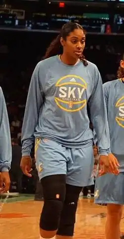 Tall woman walking towards camera wearing a Sky warmup suit