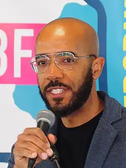 A photo of Smith at the 2024 Gaithersburg Book Festival. Smith is holding a microphone and appears to be in the middle of speaking.
