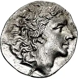 Photo of an ancient coin shows a clean-shaven man with wavy hair.