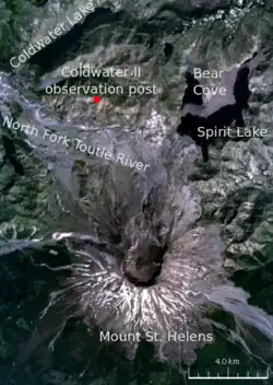 Satellite image of the area surrounding Mount St. Helens, labeled with various locations. The primary locations marked are: Mount St. Helens (in the center of the volcano there is a circular black crater); and to the north of the volcano the Coldwater II observation post, where Johnston was camped. The other locations marked are three lakes (Spirit Lake, Bear Cove, and Coldwater lake) and a river (North Fork Toutle River).