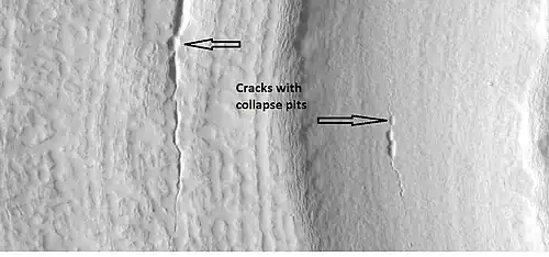 Close-up that shows cracks containing pits on the floor of a crater containing concentric crater fill, as seen by HiRISE under HiWish program.