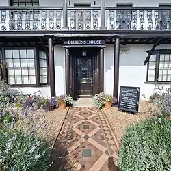 front door to a museum about charles dicken with tiled garden path in front