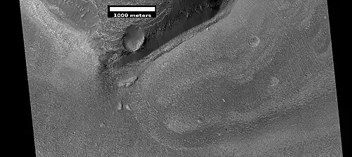 Wide view of a cliff and remains of a glacier, as seen by HiRISE under HiWish program