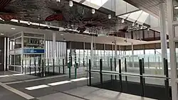 A station concourse above platform level with lifts that link down to platform level