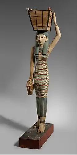 Figurine of a female servant carrying provisions; 1981–1975&nbsp;BC; painted wood and gesso; 112 × 17&nbsp;cm; Metropolitan Museum of Art (New York City)