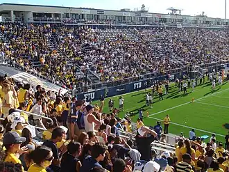 Football fans standing in the bleachers of a stadium