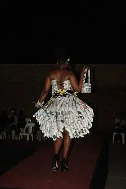 Fashion and Wellness shows a "Model showcasing a dress made out bulletin newspapers, this is an attempt towards clearing the environment and keeping it clean". This is from the theme "Health and wellness in Africa."