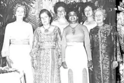 Six women in dresses standing together, standing together for group photo, smiling