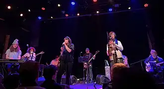 Eight musicians performing on a stage