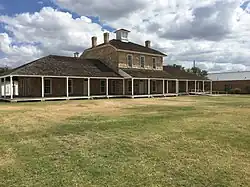 The post hospital, rebuilt in the 1980s, from the parade ground: The north ward is the leftmost section of the building.