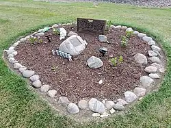 A ring of rocks surrounds memorial plaques