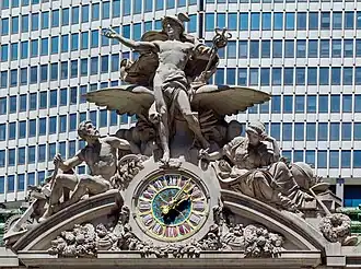A large clock and stone sculptural group adorning the building's facade