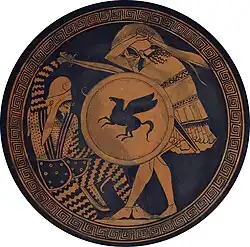 An illustration on a circular surface in golden-yellow watercolor. A standing Greek soldier with a unicorn shield is sword fighting with a lunging Persian soldier wearing a drooping cap