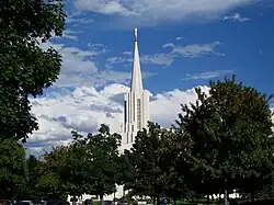 Looking at a spire of a church coming up out of the trees