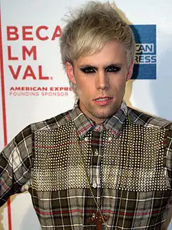 A color photograph of American singer-songwriter Justin Tranter, who is posing in front of a stand and repeat at a 2009 film festival.