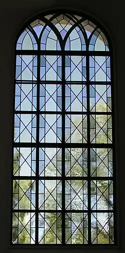 Post-Modern leadlighting combining traditional diamond pane form with the squareness of an iron armature and the arch of a church window in a design of great precision and subtlety. Karlstad Cathedral, Sweden.